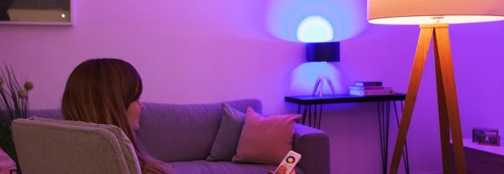 Person steuert Beleuchtung mit Fernbedienung